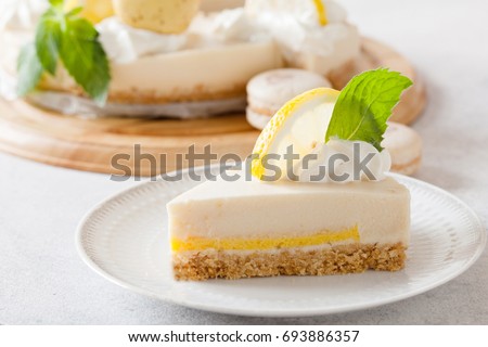 Slice of cheesecake with lemon filling decorated with macarons and flowers. Healthy organic summer dessert pie. 