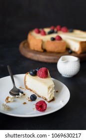 Slice of cheesecake with missing bite on white plate. selective focus