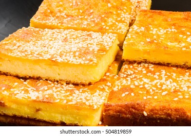 Slice of cheesecake with sesame seeds on a black background - Shutterstock ID 504819859