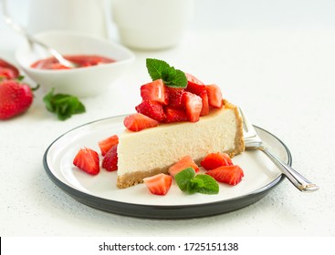 Slice of cheesecake with strawberries, mint and sauce. Selective focus
