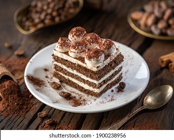 Slice of chocolate cake with tiramisu cream and cocoa powder on wooden table. - Shutterstock ID 1900238956