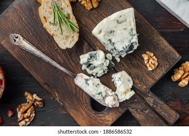 Slice of danish blue cheese, on dark wooden background, flat lay