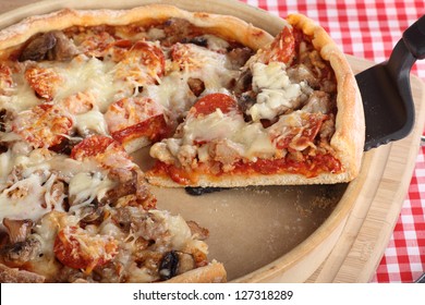 Slice Of Deep Dish Sausage And Pepperoni Pizza In A Pizza Pan