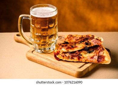 Slice of delicious homemade pizza served with light cold beer on the wooden board on yellow brown background. Pizza time - Powered by Shutterstock