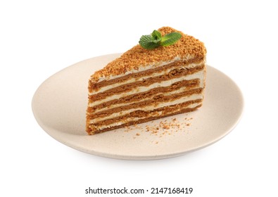 Slice of delicious layered honey cake with mint isolated on white
