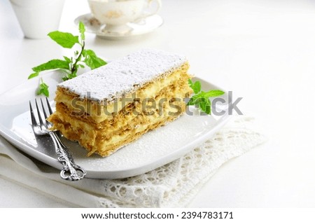 A slice of delicious thousand leaves cake isolated on white background. Mille-feuille, traditional French dessert also known as Napoleon.