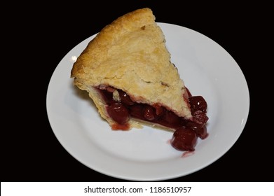 Slice of double crusted cherry pie on black background. Traditionally, cherry pie is made with tart rather than sweet cherries.