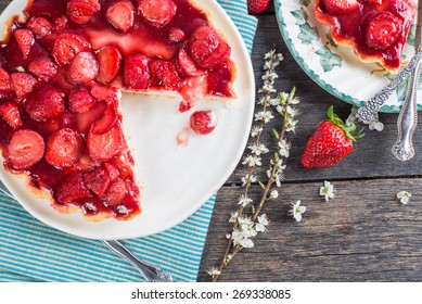 Slice Of Fresh Homemade Strawberry Tart With Flowers From Above On Wooden Table