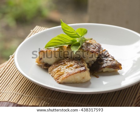 A slice of  fried fish on plate.