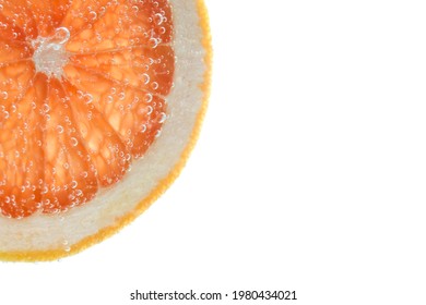 Slice Of Grapefruit In Sparkling Water On White Background, Closeup. Citrus Soda