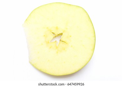 Slice of green apple with empty seed star in the middle cut at the side isolated on white background, top view and close up. Natural and healthy food