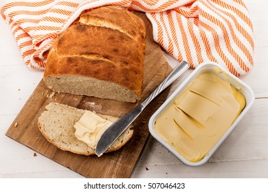 Slice Home Baked Bread With Margarine And Knife On A Cutting Board