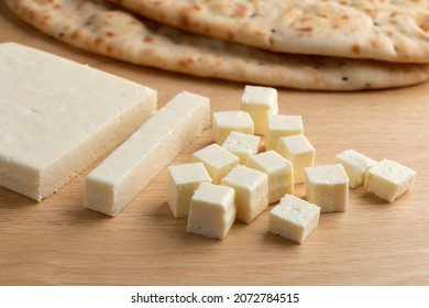 Slice Of Indian Paneer Cheese, Cubes And Naan In The Background 