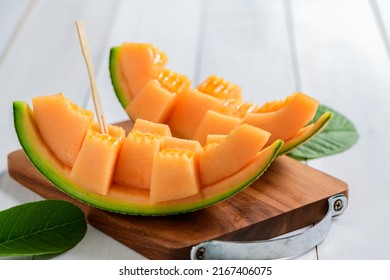slice of japanese melons, orange melon or cantaloupe melon on white wood background, summer fruits