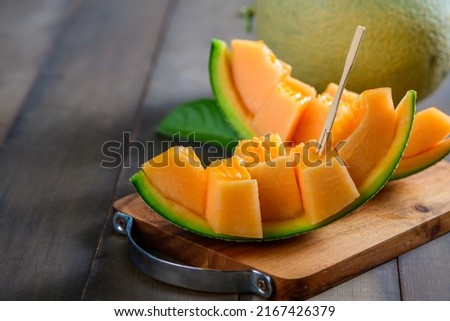 slice of japanese melons, orange melon or cantaloupe melon on wood background, summer fruits