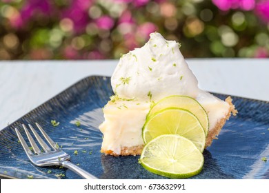 A Slice Of Key Lime Pie Served With Whipped Cream And Lime Zest