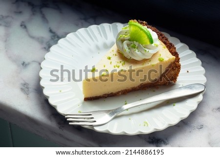 Slice of Key Lime Pie with Whipped Cream and Lime Zest on a Plate	