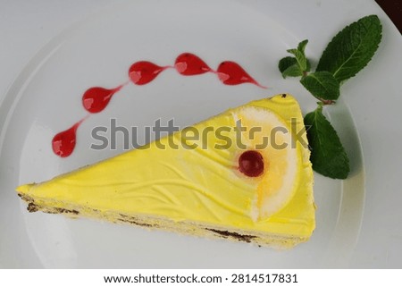 Slice of Lemon Cake with Mint and Berry Sauce on Plate