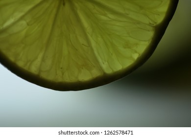 A slice of a lime with a light behind it.