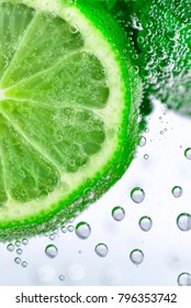 A slice of lime and a peppermint leaf in soda water. Mojito close up. 