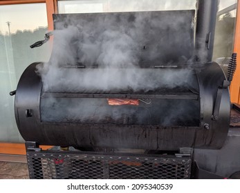 A Slice Of Meat Being Cooked In A Charcoal Smoker