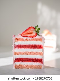 Slice of mouth-watering strawberry cake. Close-up, layers of cream, compote and rose sponge cake, fresh strawberries on top.