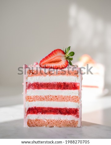 Slice of mouth-watering strawberry cake. Close-up, layers of cream, compote and rose sponge cake, fresh strawberries on top.