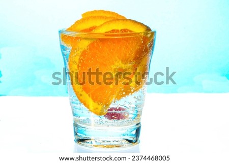a slice of orange with bubbles in a glass of sparkling water. Close-up