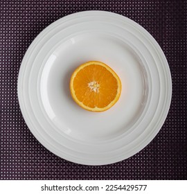 Slice of orange on a white plate - Shutterstock ID 2254429577
