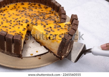 slice of passion fruit tart decorated with chocolate cookies onwhite background