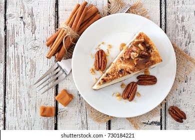 Slice Of Pecan Caramel Cheesecake, Top View On A Rustic White Wood Background