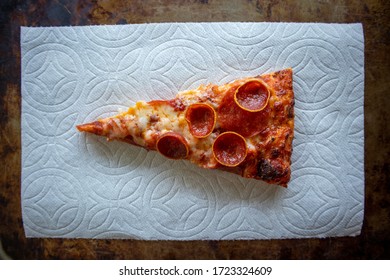 A Slice Of Pepperoni Pizza On A White Napkin