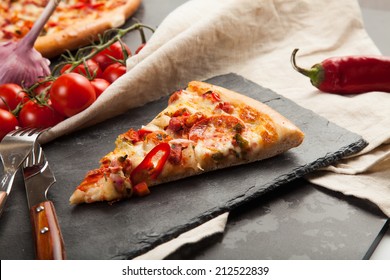 A Slice Of Pizza Is On A Stone Plate Around Her Ingredients Closeup