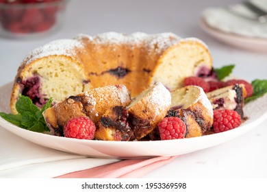 A Slice Of Raspberry Breakfast Bundt Cake With A Powdered Sugar Dusting On Top.