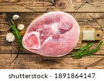 Slice of raw pork knuckle, leg. Farm fresh meat. Wooden background. Top view.