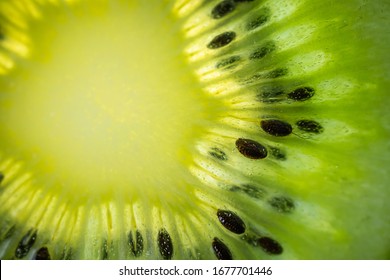 A Slice Of Ripe Juicy Kiwi Closeup. Detailed Bright Macro Photo. The Concept Of Fruit Harvest, Vegetarianism, Useful Healthy Food, Vitamins. Abstract Food Image.