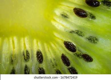 A Slice Of Ripe Juicy Kiwi Closeup. Detailed Bright Macro Photo. The Concept Of Fruit Harvest, Vegetarianism, Useful Healthy Food, Vitamins. Abstract Food Image.