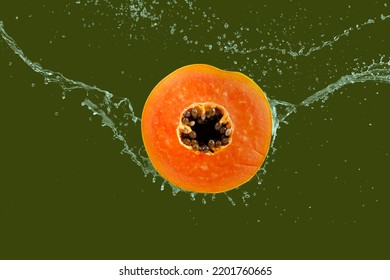 Slice Of The Ripe Papaya Fruit With Splashing Water Isolated On Green Background With Clipping Path