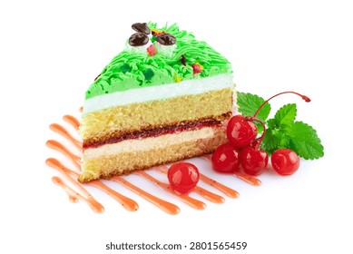 A slice of sponge cake decorated with bright green cream resembling grass and miniature sugar mushrooms, served with cocktail cherries, isolated on a white background.