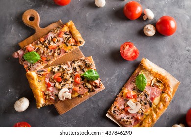 A Slice Of Square Pizza With Basil Tomatoes And Mushrooms On A Wooden Board.