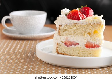 Slice of strawberry shortcake with white chocolate shavings.