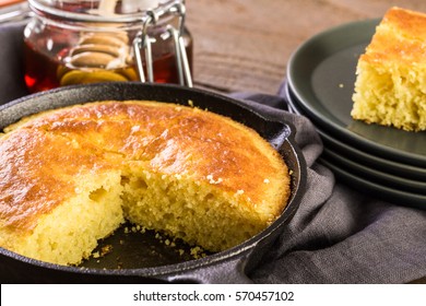Slice of sweet cornbread with honey on the plate.
