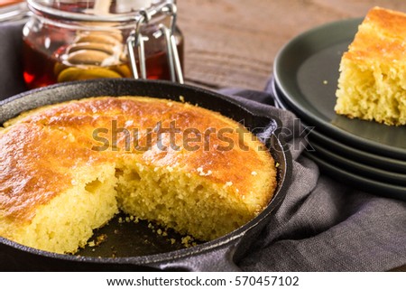 Slice of sweet cornbread with honey on the plate.
