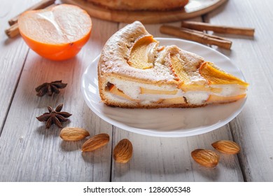 A Slice Of Sweet Persimmon Pie On White Wooden Background. Close Up.