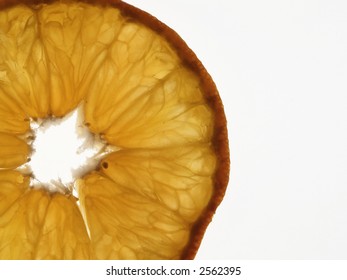 Slice through a mandarin orange, backlit and isolated on white, with copy space to right.