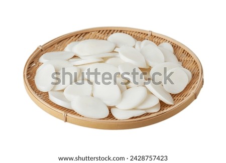 slice Tteok or slice Korean rice cake in wooden bowl isolated on white background. slice Tteok or Korean rice cake isolated. Tteok rice cake.