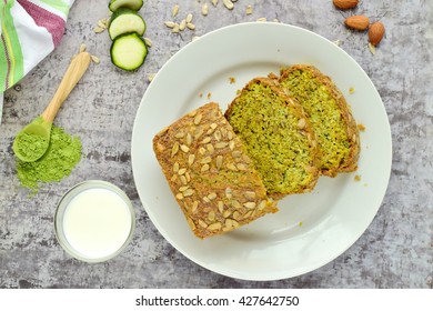 Slice of wheat grass zucchini bread with sunflower seeds served with a glass of milk