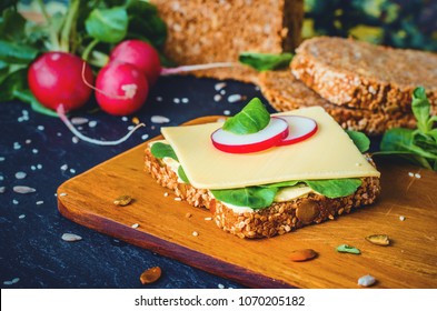 Slice Of Whole Grain Bread With Cheese, Salat And Radish On Wooden Board