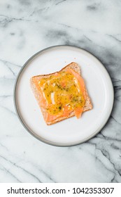 Slice Of Wholegrain Toast With Butter, Scandinavian Cured Or Smoked Salmon, Called Gravad Lax In Sweden, Served With Mustard And Dill Sauce On White Plate On Marble Plate