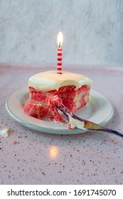 Slice Of Yellow Jello Cake With Pudding Frosting With A Single Lit Candle On Plate With Fork